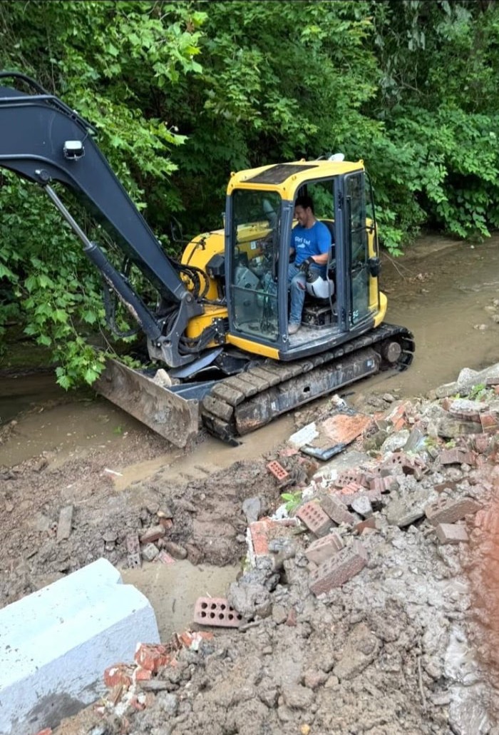 Excavator clearing a creek bank